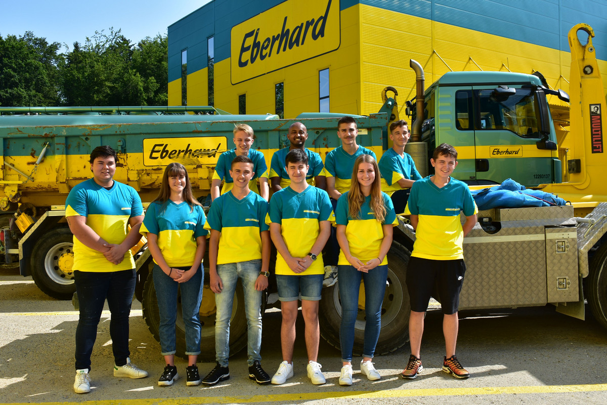 Die Lernenden der Eberhard Unternehmungen posieren als Gruppe vor einem Lastwagen.